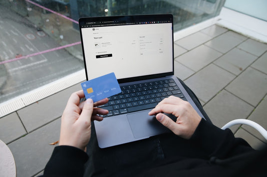 A person shopping online on a laptop with a credit card, representing modern eco-friendly shopping trends